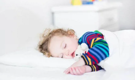 Toddler girl sleeping on a bed