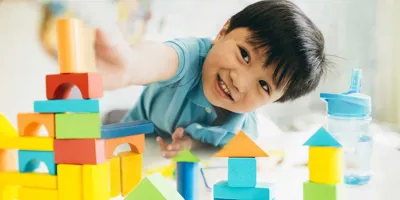 A young boy playing with colourful wooden toys